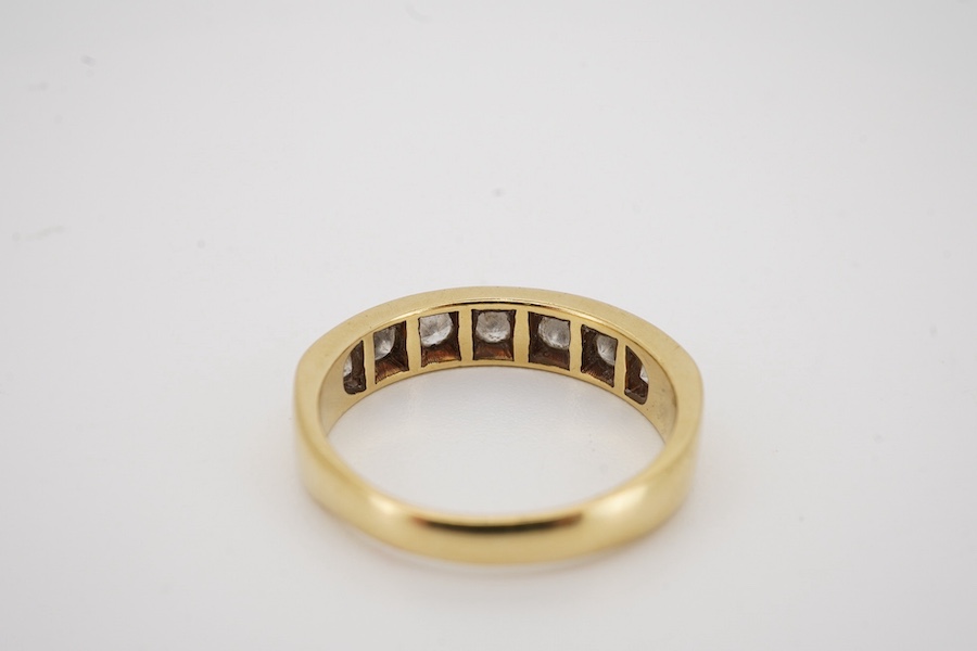 A modern 18ct gold and seven stone diamond set half hoop ring, size M, gross weight 4 grams.